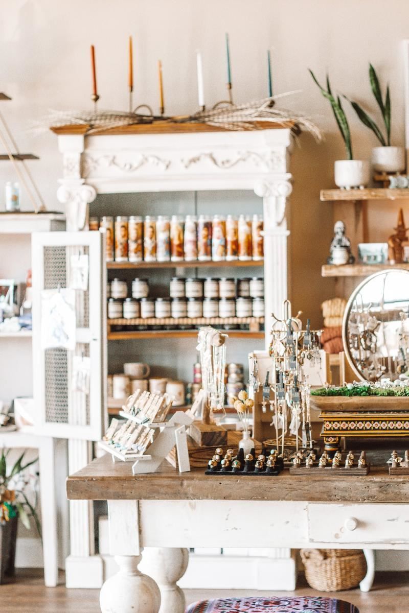 A room with a table , shelves , candles and a mirror.