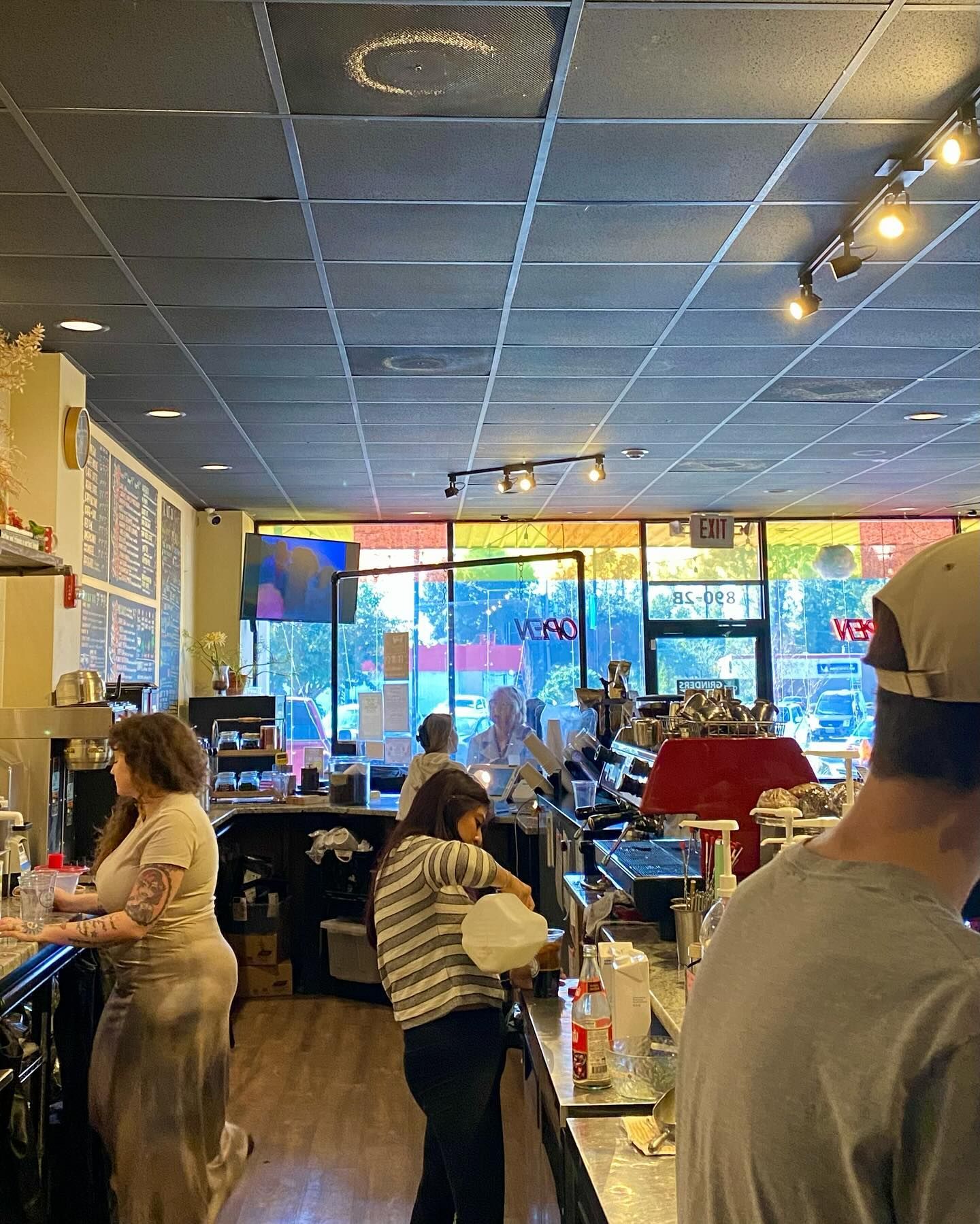 A group of people are standing at a counter in a restaurant.