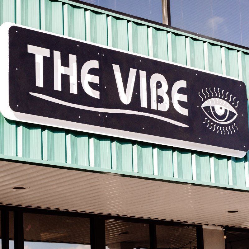 A sign on the side of a building that says the vibe