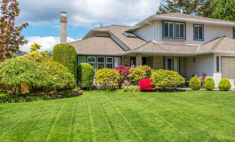 A large white house with a lush green lawn in front of it.