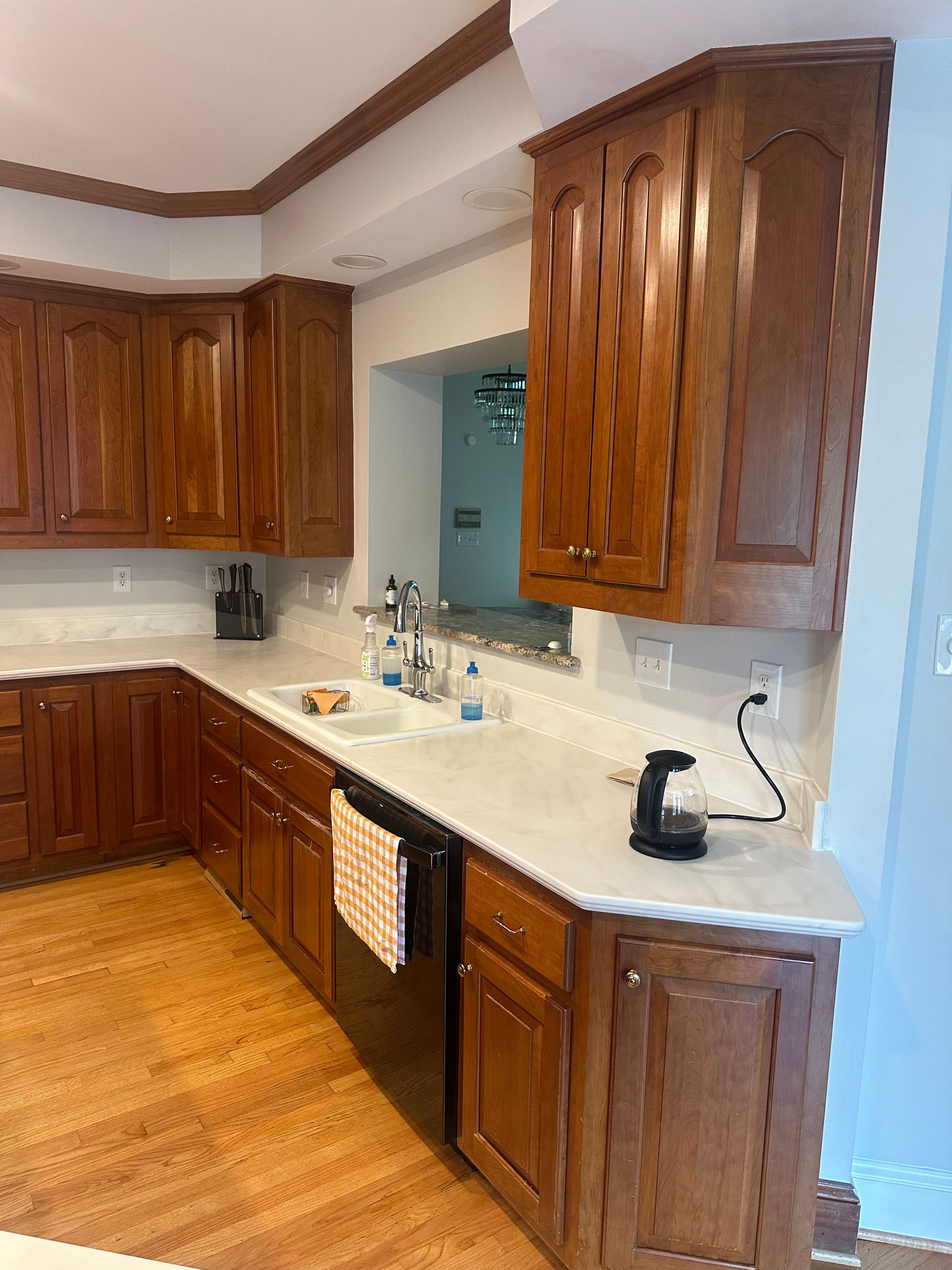 Kitchen with brown cabinets, white countertops, and hardwood floors.