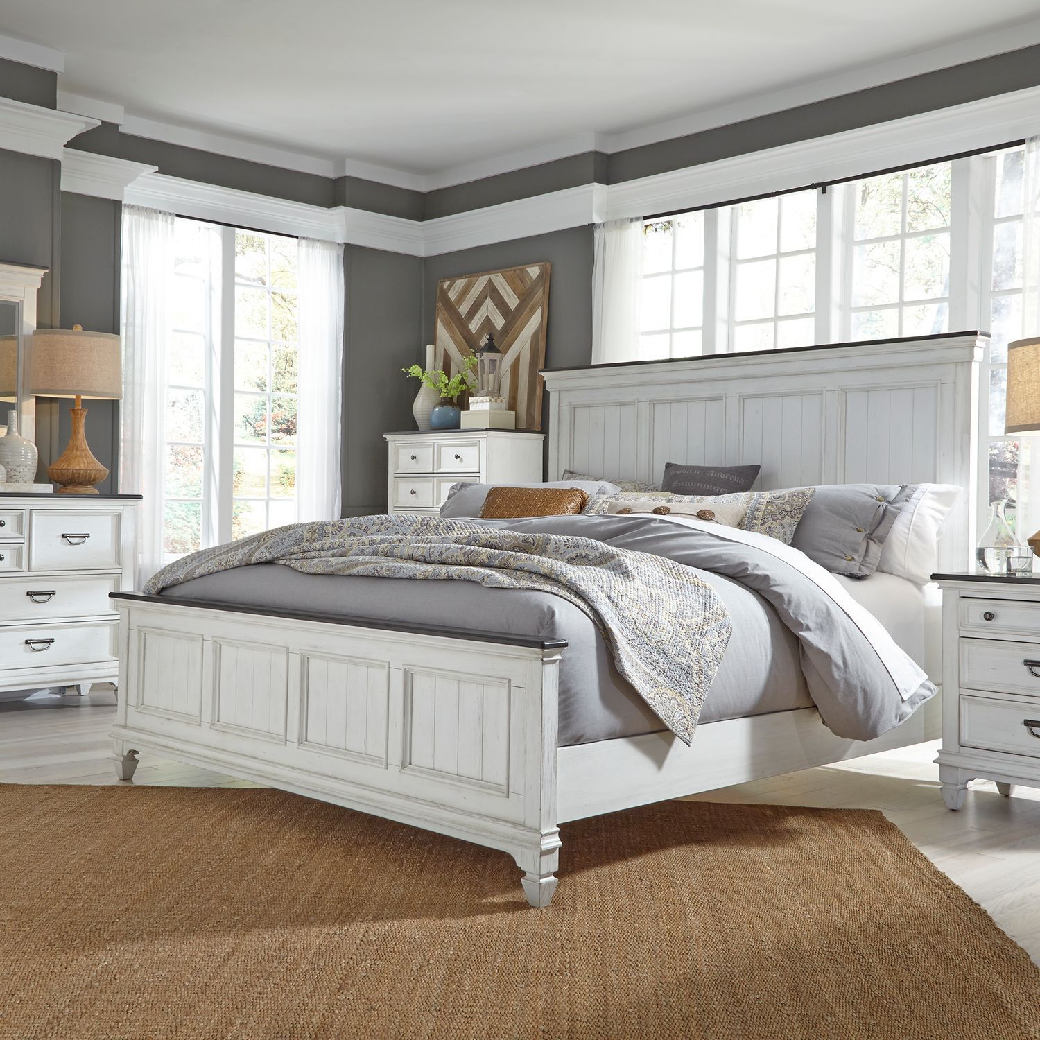 A bedroom with a bed , dresser , nightstand and rug.