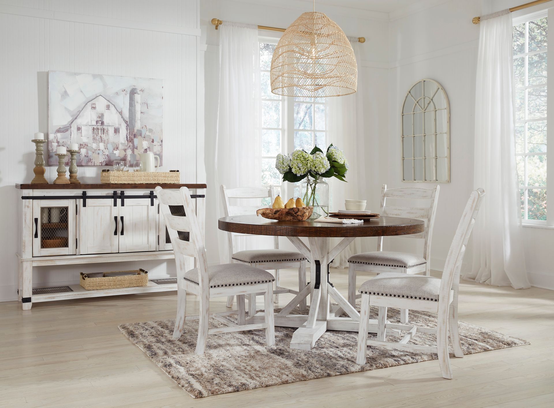 A dining room with a table and chairs and a rug.