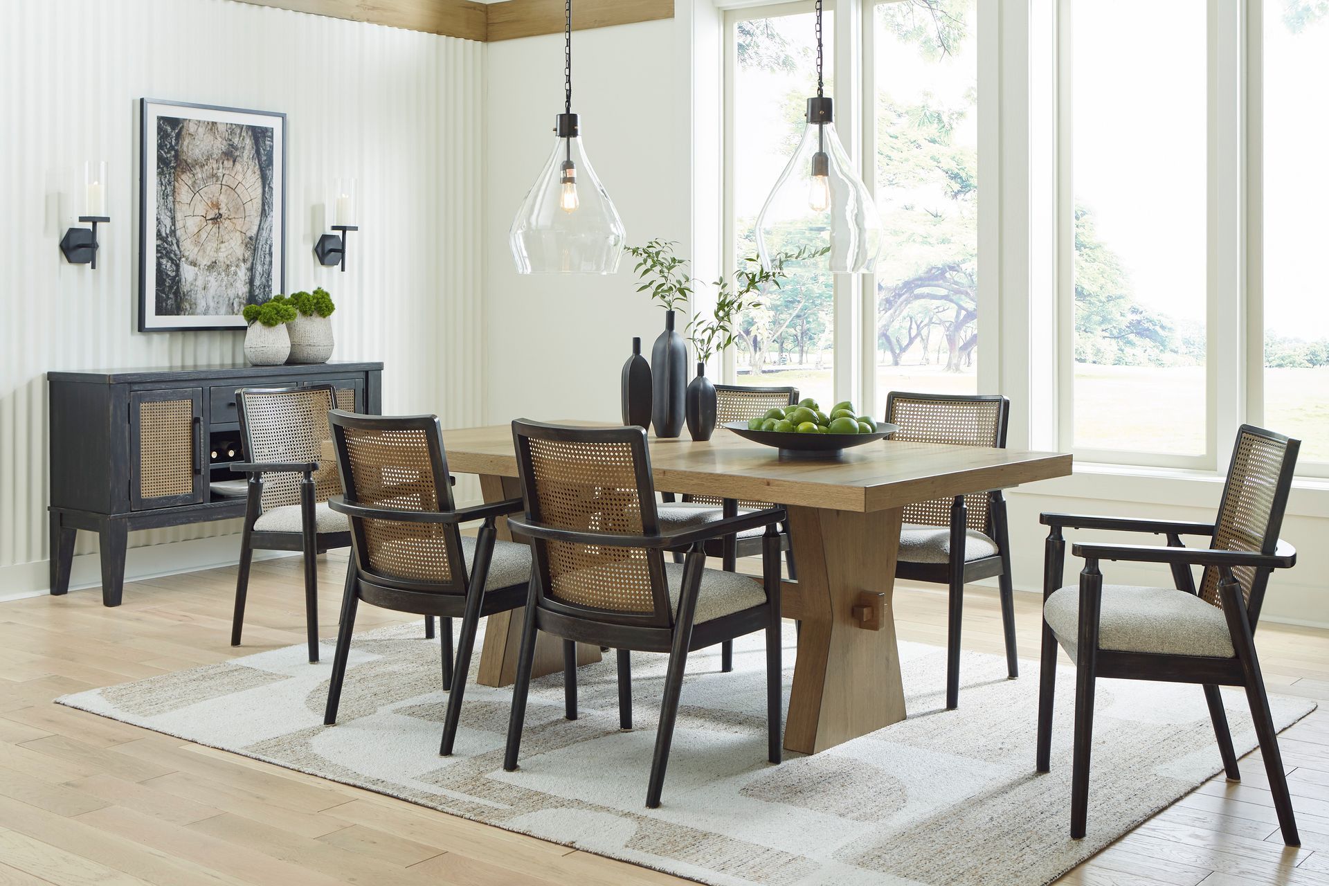 A dining room with a table and chairs and a rug.