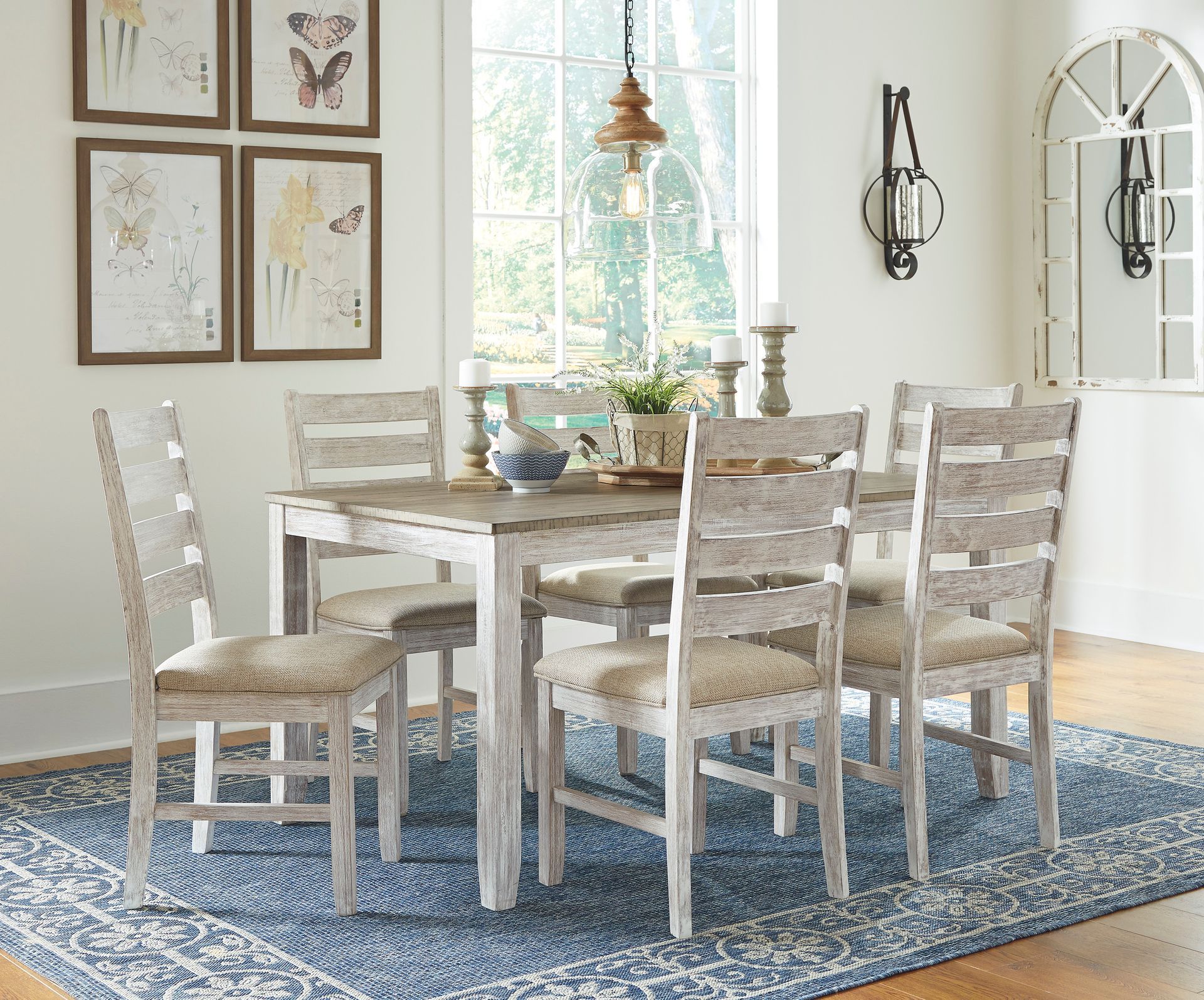 A dining room with a table and chairs and a rug.