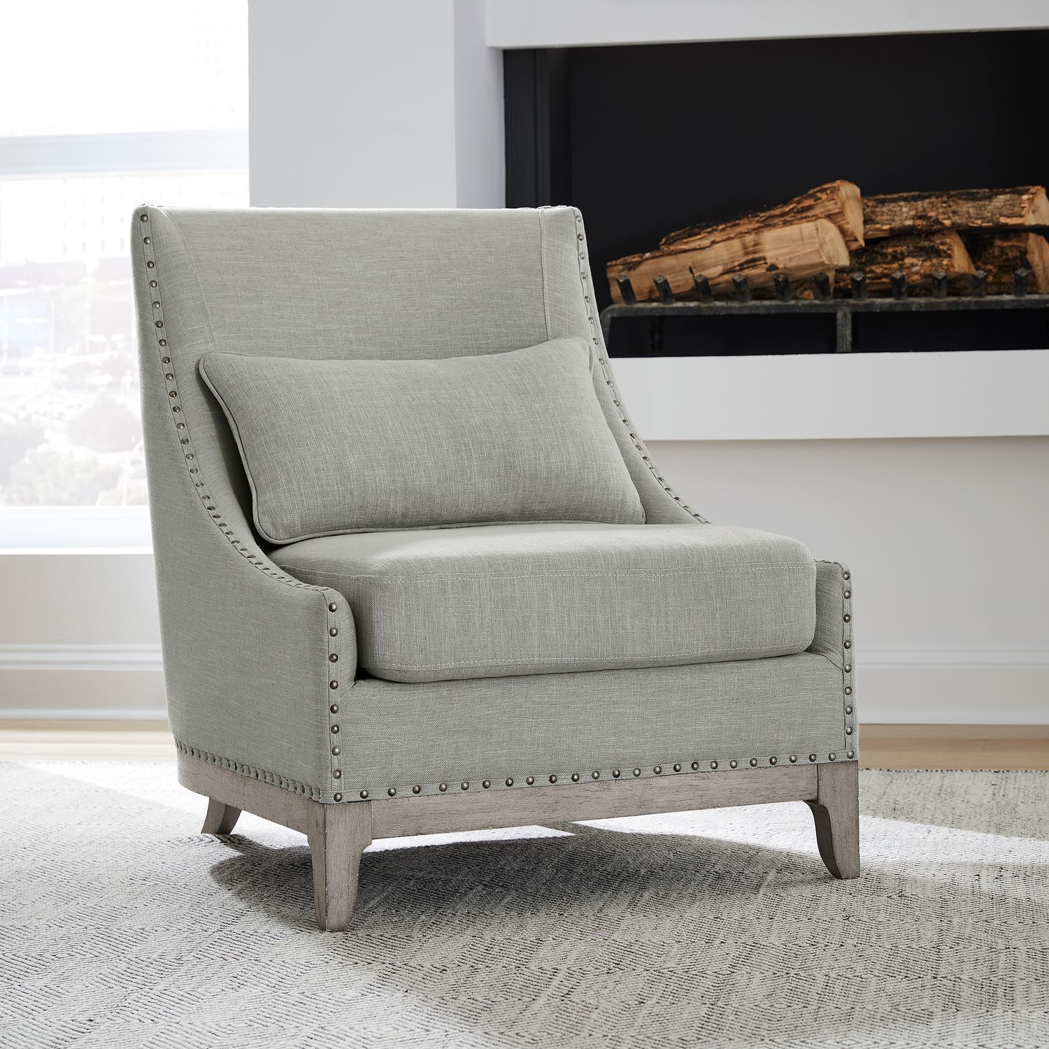 A chair is sitting in front of a fireplace in a living room.