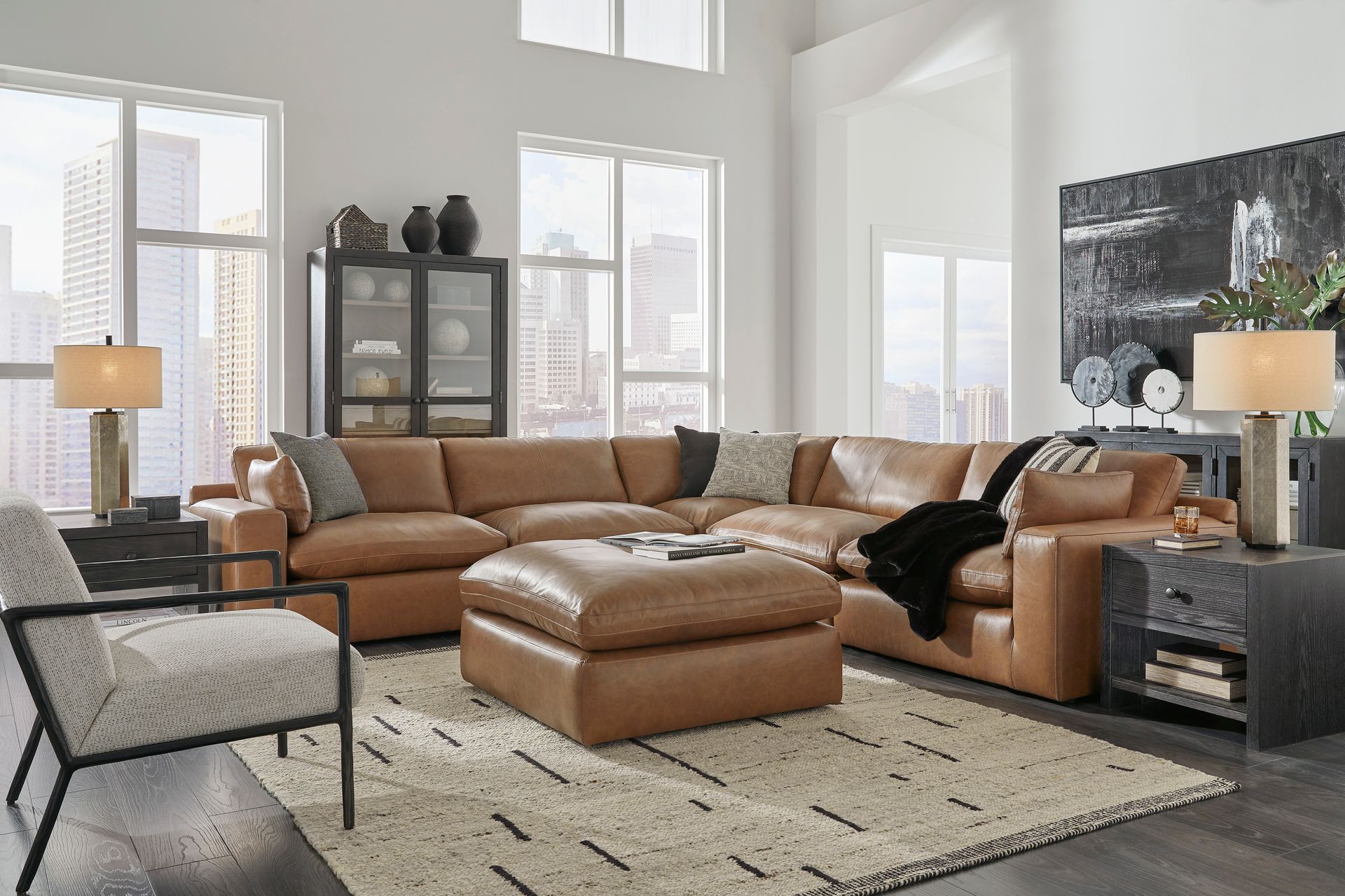 A living room with a large sectional couch , chair , ottoman and rug.