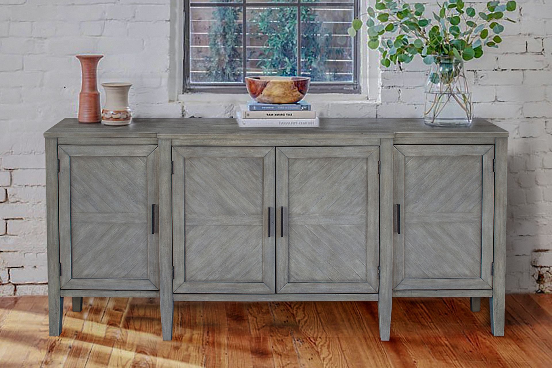 A gray dresser is sitting in a living room next to a window.