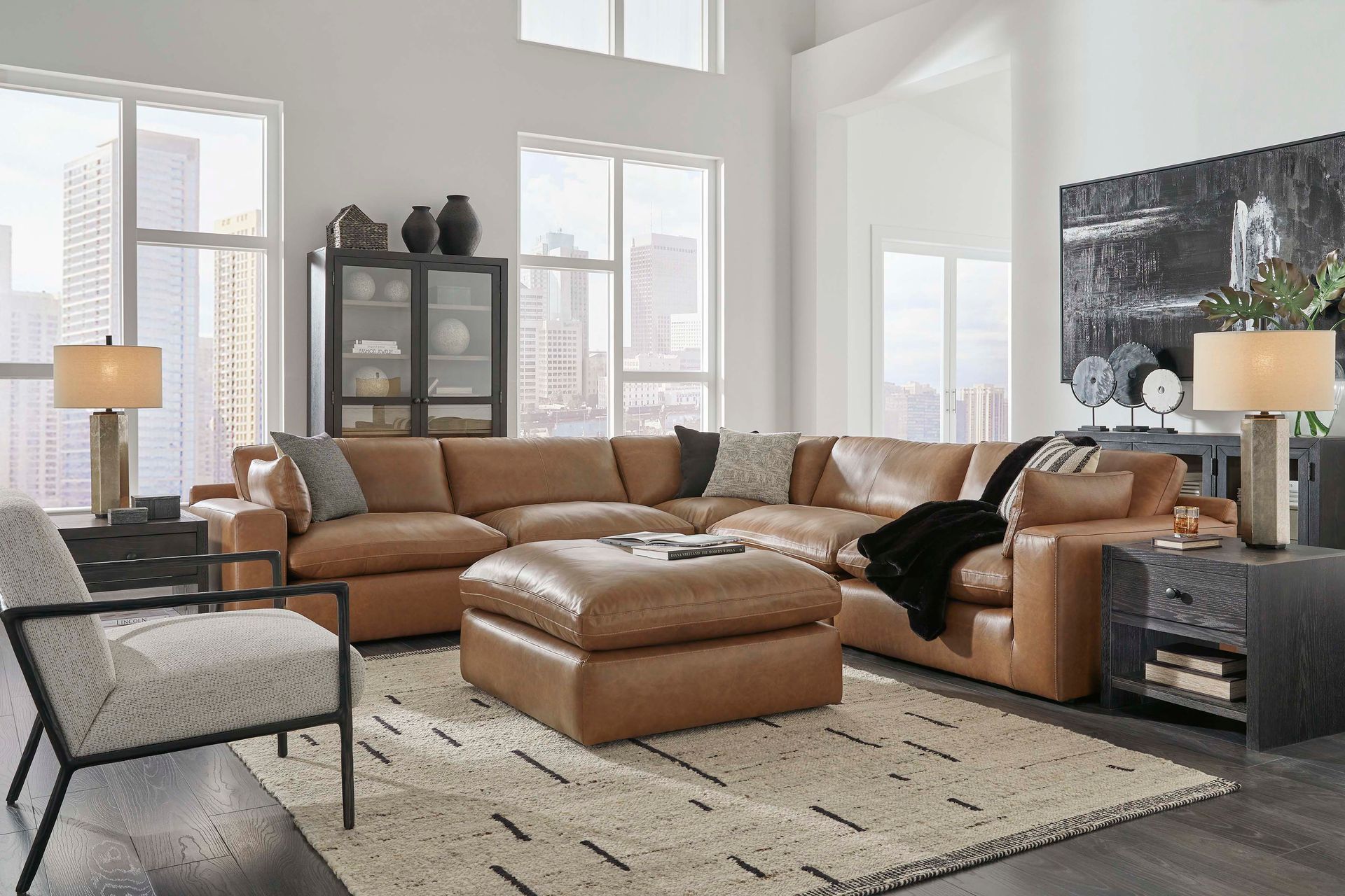 A living room with a large sectional couch , chair , ottoman and rug.