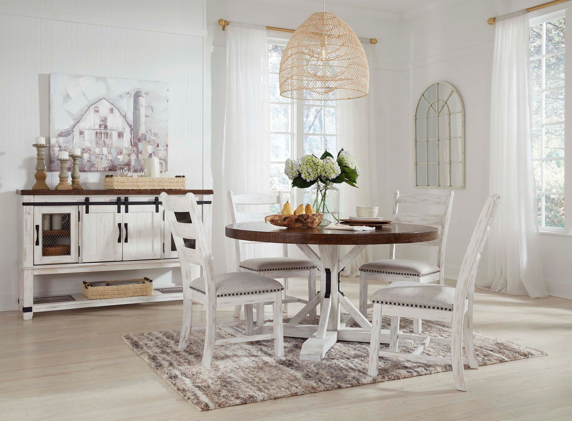 A dining room with a table and chairs and a rug.