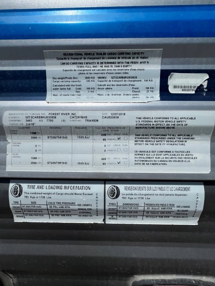 Labels with vehicle information, including tire inflation and weight capacity, affixed to a blue truck.