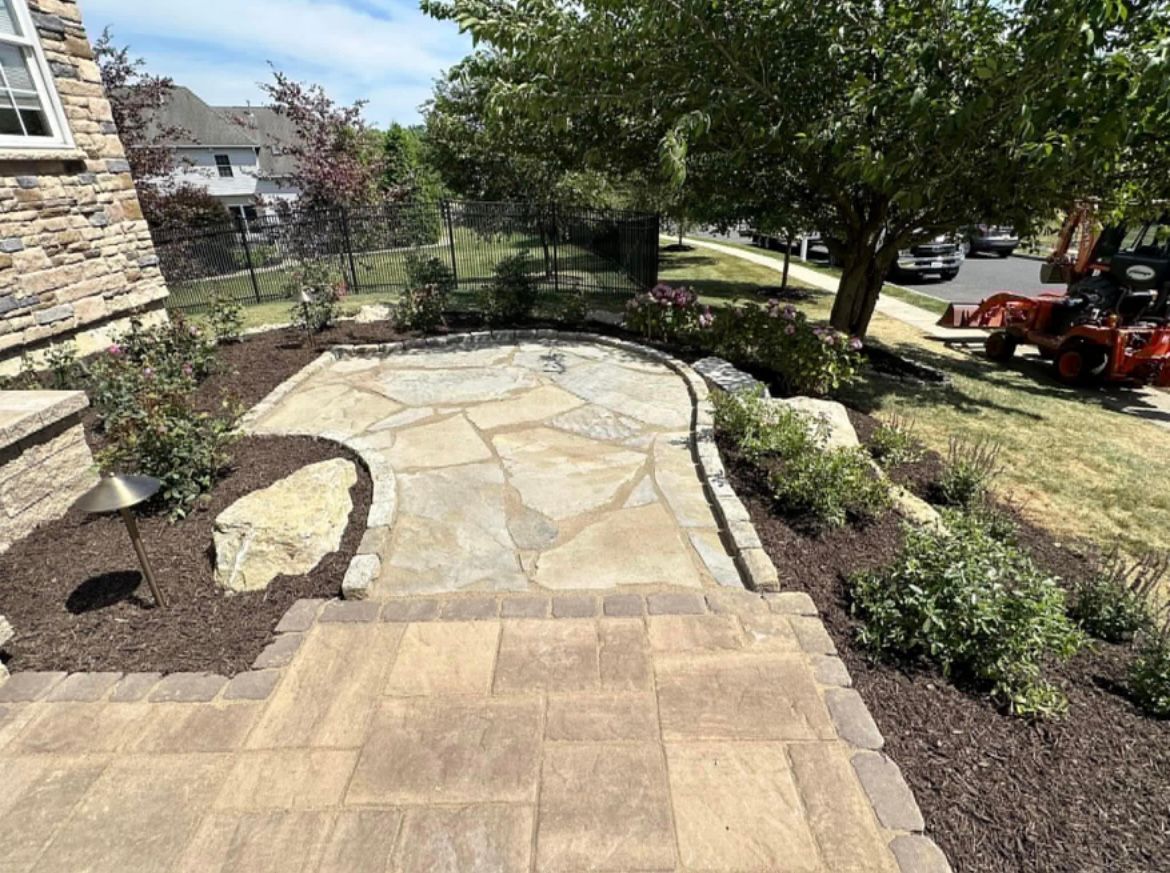 A patio with a lawn mower parked in front of a house.