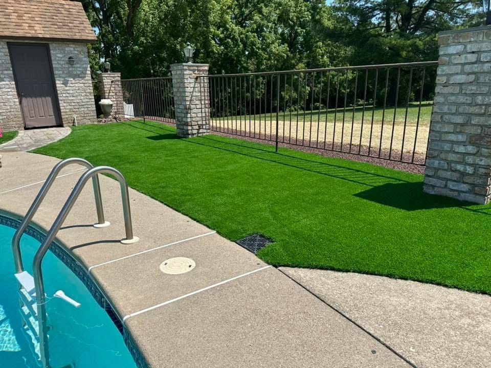 A swimming pool surrounded by a lush green lawn.
