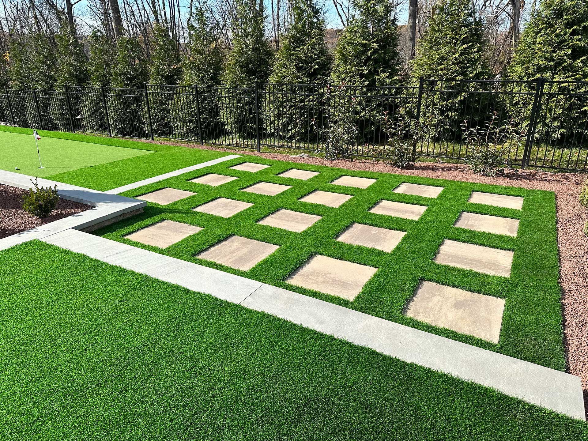 Artificial grass with a walkway and a putting green in the background