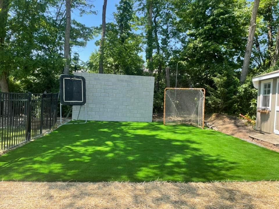 grass with a wall and soccer goals