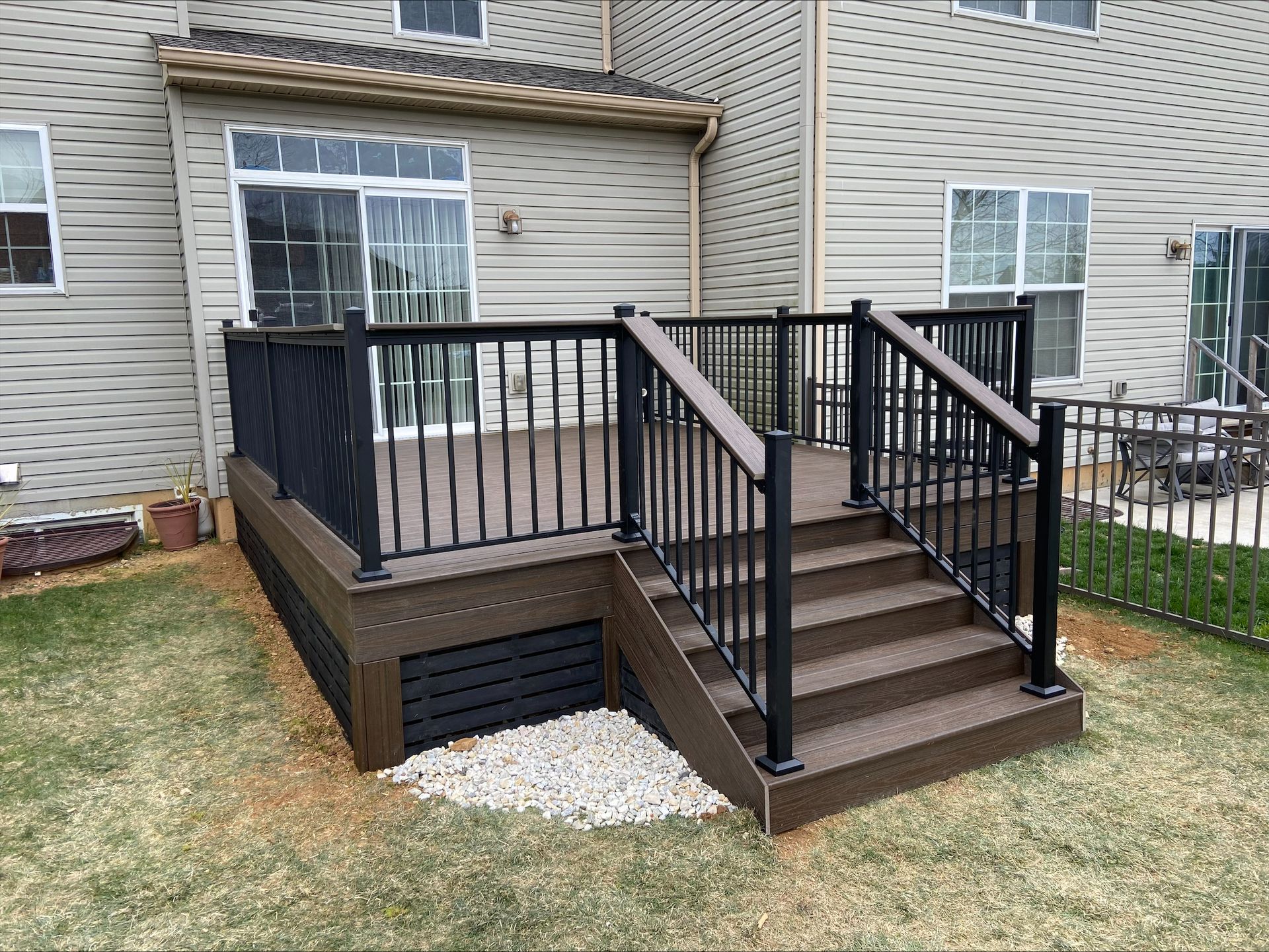 A deck with stairs leading up to it in front of a house.