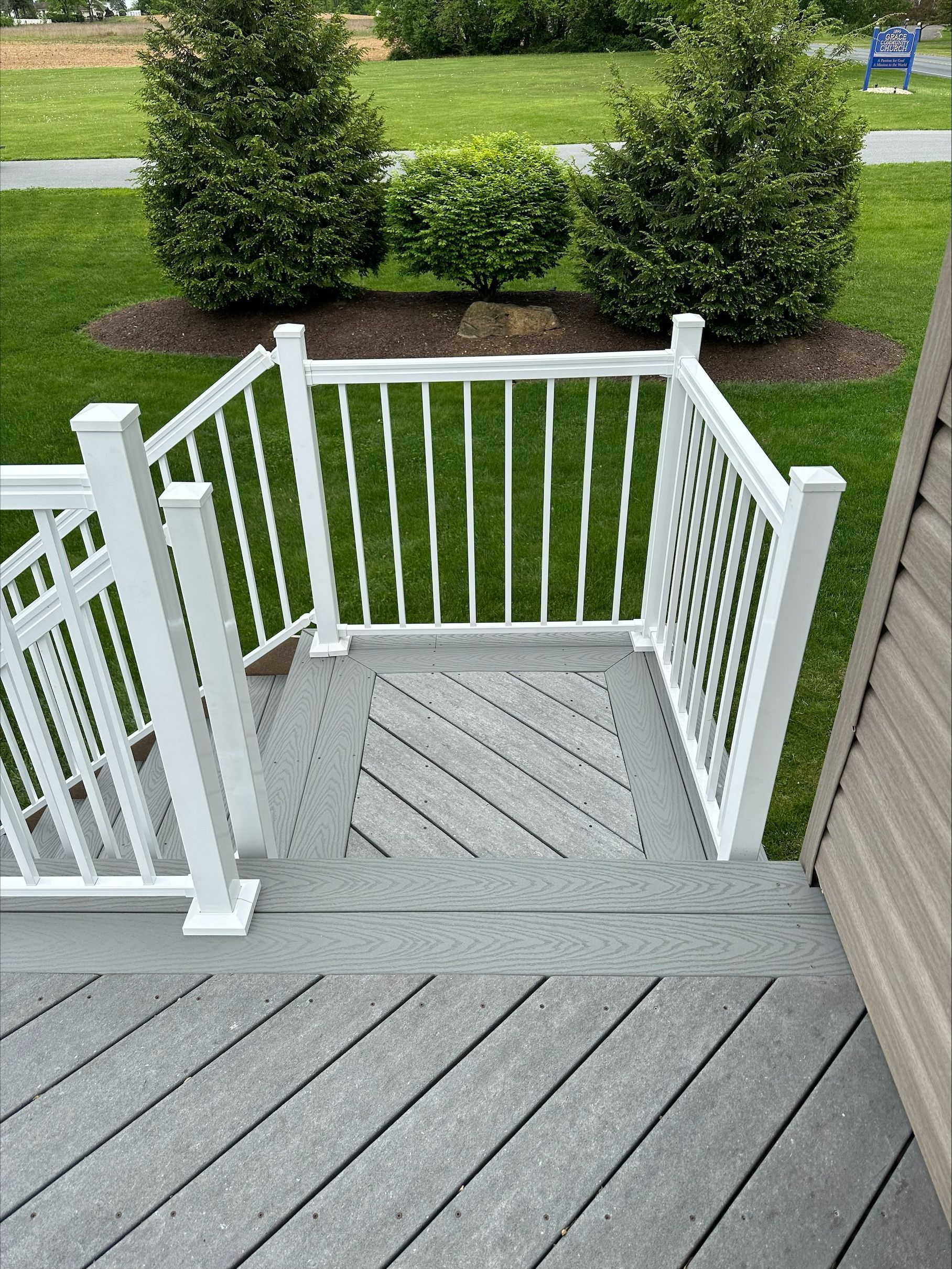 A staircase leading up to a deck with a white railing.