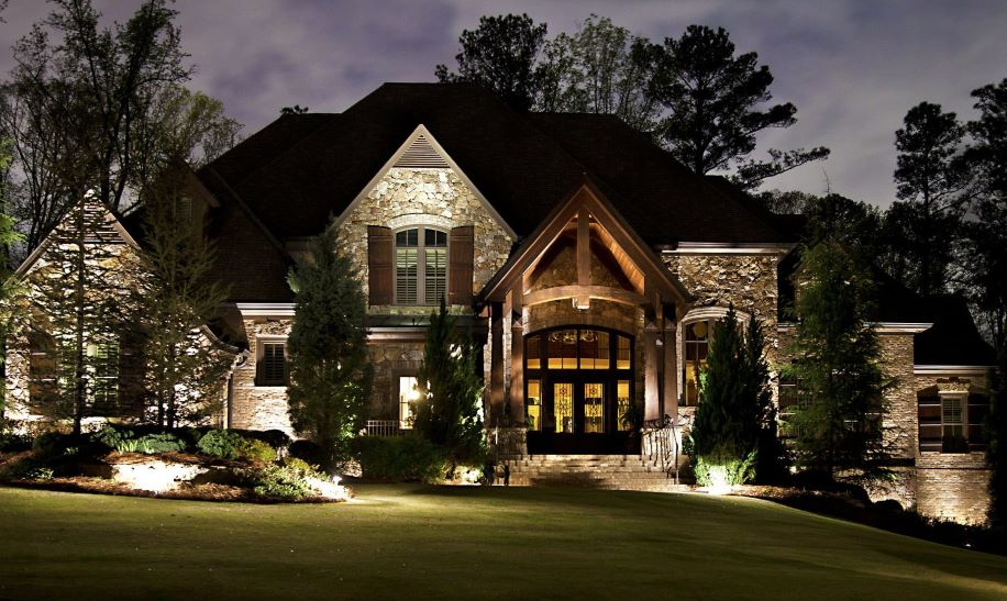front of a huge house with trees and lighting