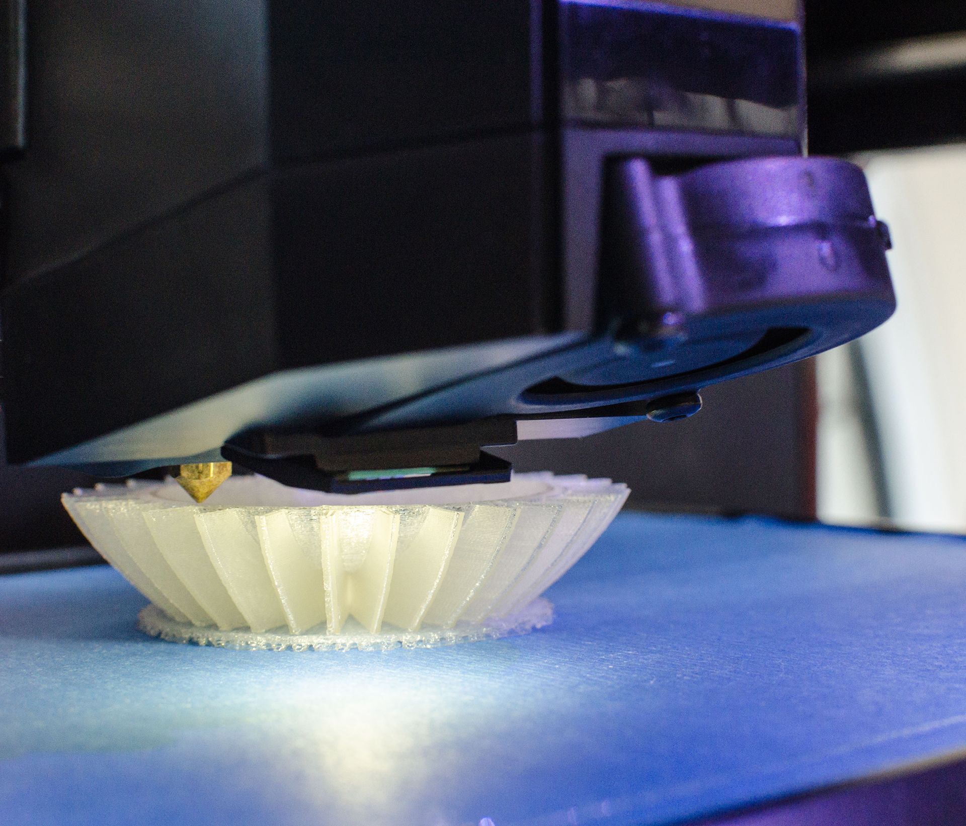 3D printer printing a white plastic piece