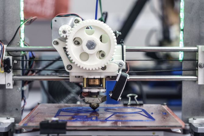 3D printer printing a blue object on its build plate