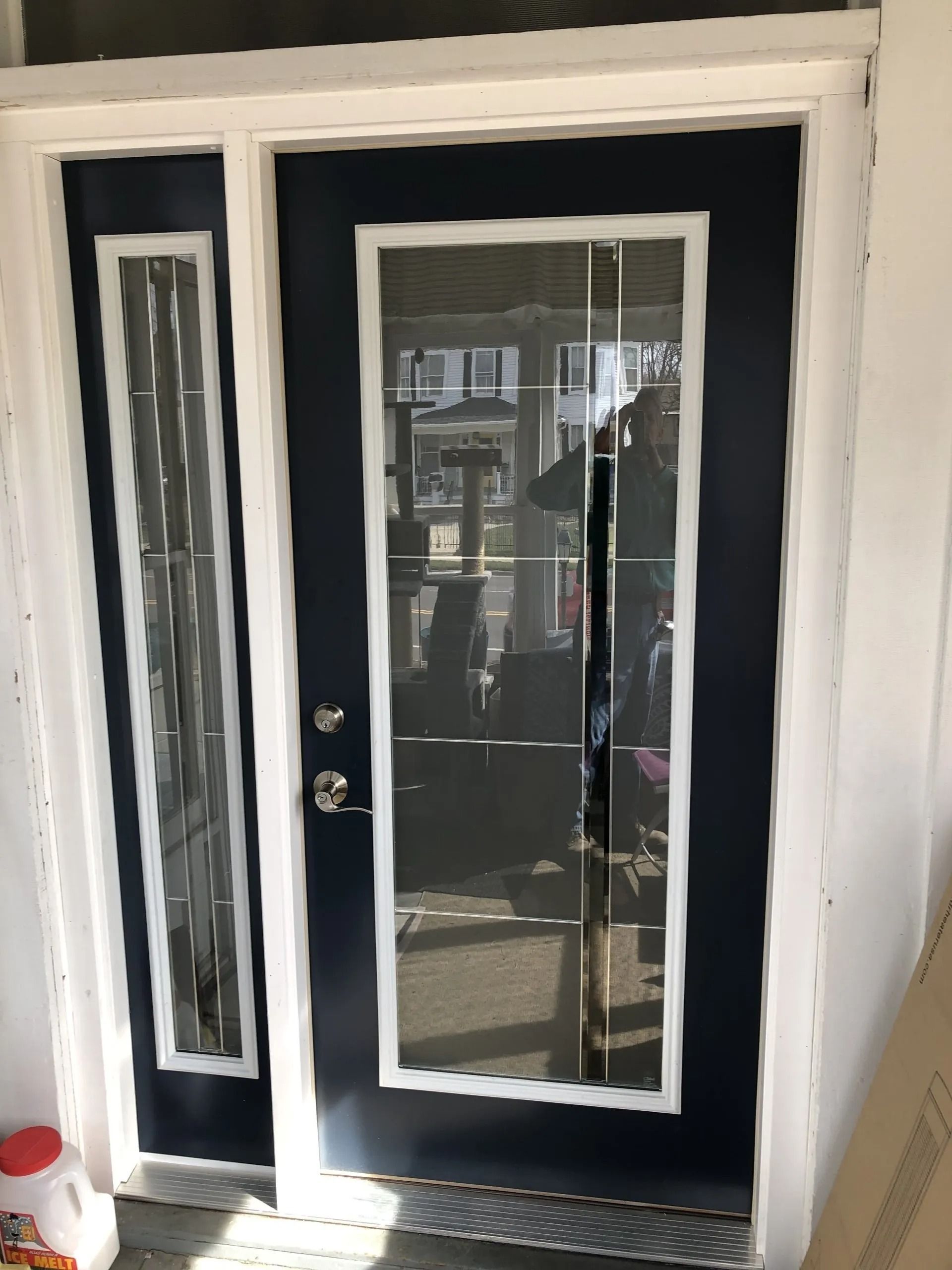Blue front door with white trim and narrow glass sidelights