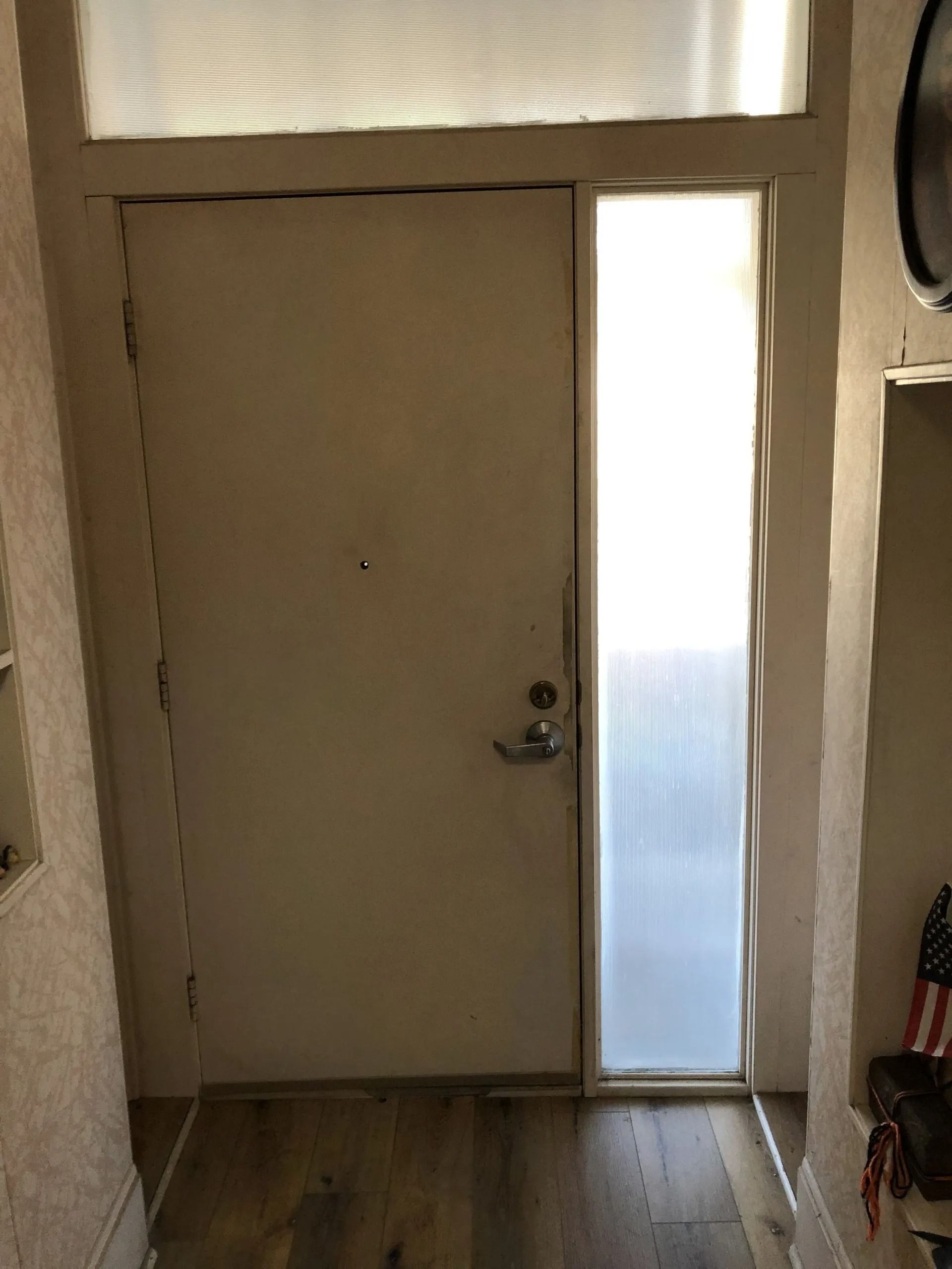 Front door with narrow frosted glass panel and daylight coming through
