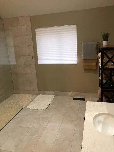 Bathroom with walk-in shower, tiled floor, bathtub, and a window with blinds.