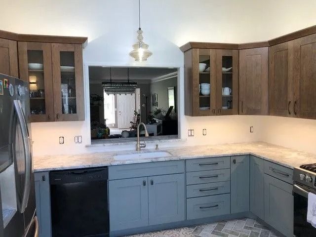 Kitchen with dark wood cabinets, light countertops, and a black dishwasher and stove.
