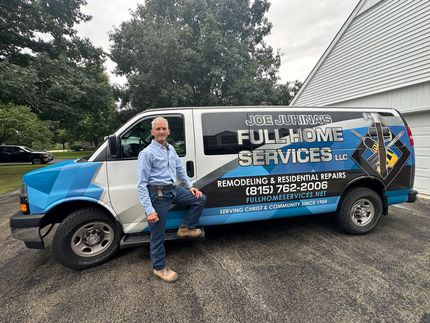 Worker sitting on a blue-and-white service van with &ldquo;Full Moon Services&rdquo; lettering in a gravel driveway