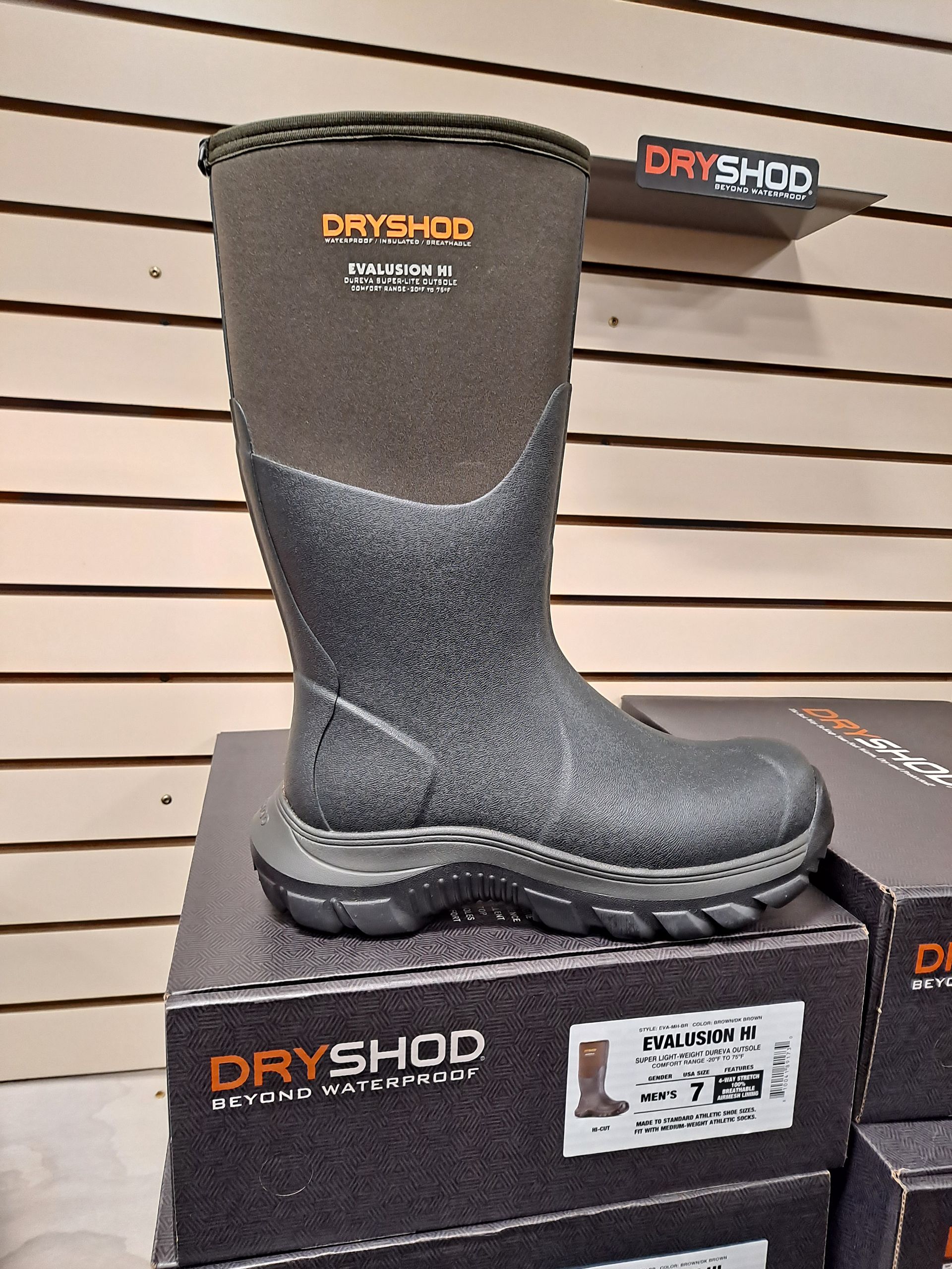 A pair of dry-shod boots sitting on top of a stack of boxes.