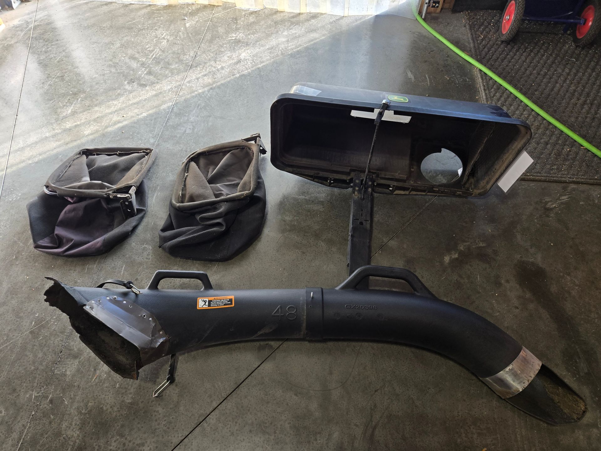 A red and black lawn mower is parked in a gravel lot.