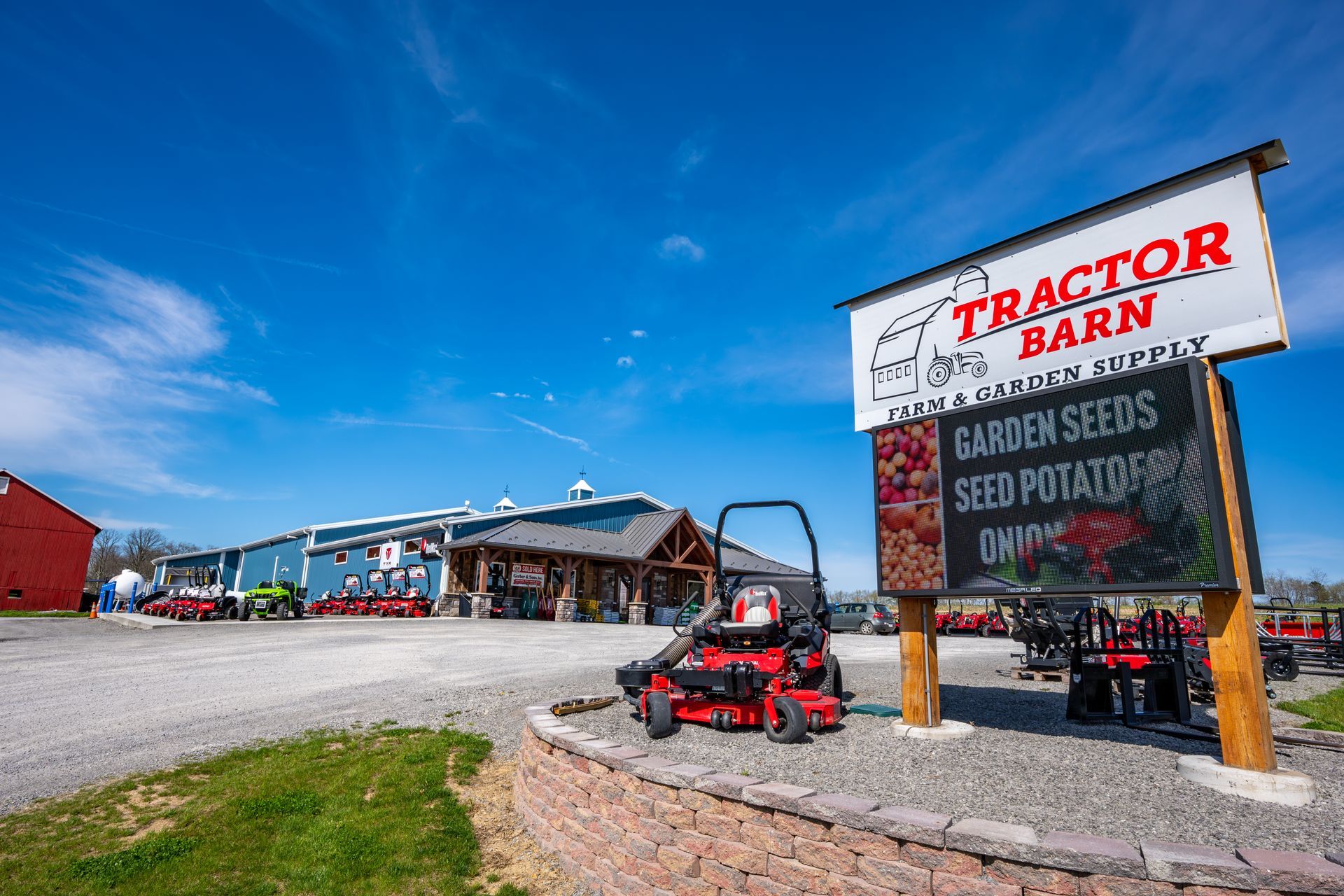A sign for the tractor barn is above a brick wall.