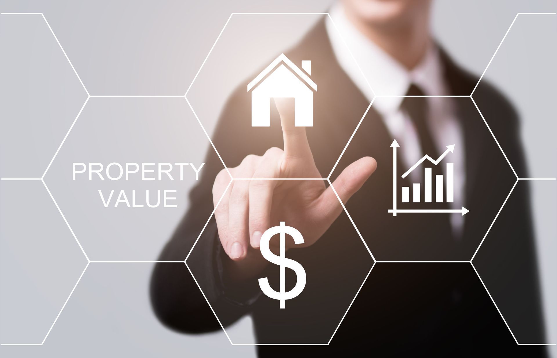 Person in suit pointing at a house icon, with property value symbols, representing real estate.