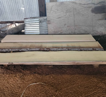 A wooden bench is sitting on top of a pile of dirt.