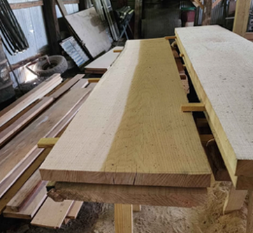 A large piece of wood is sitting on top of a wooden table.