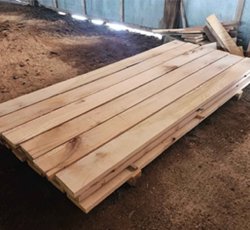 A pile of wood is sitting on the ground in a warehouse.
