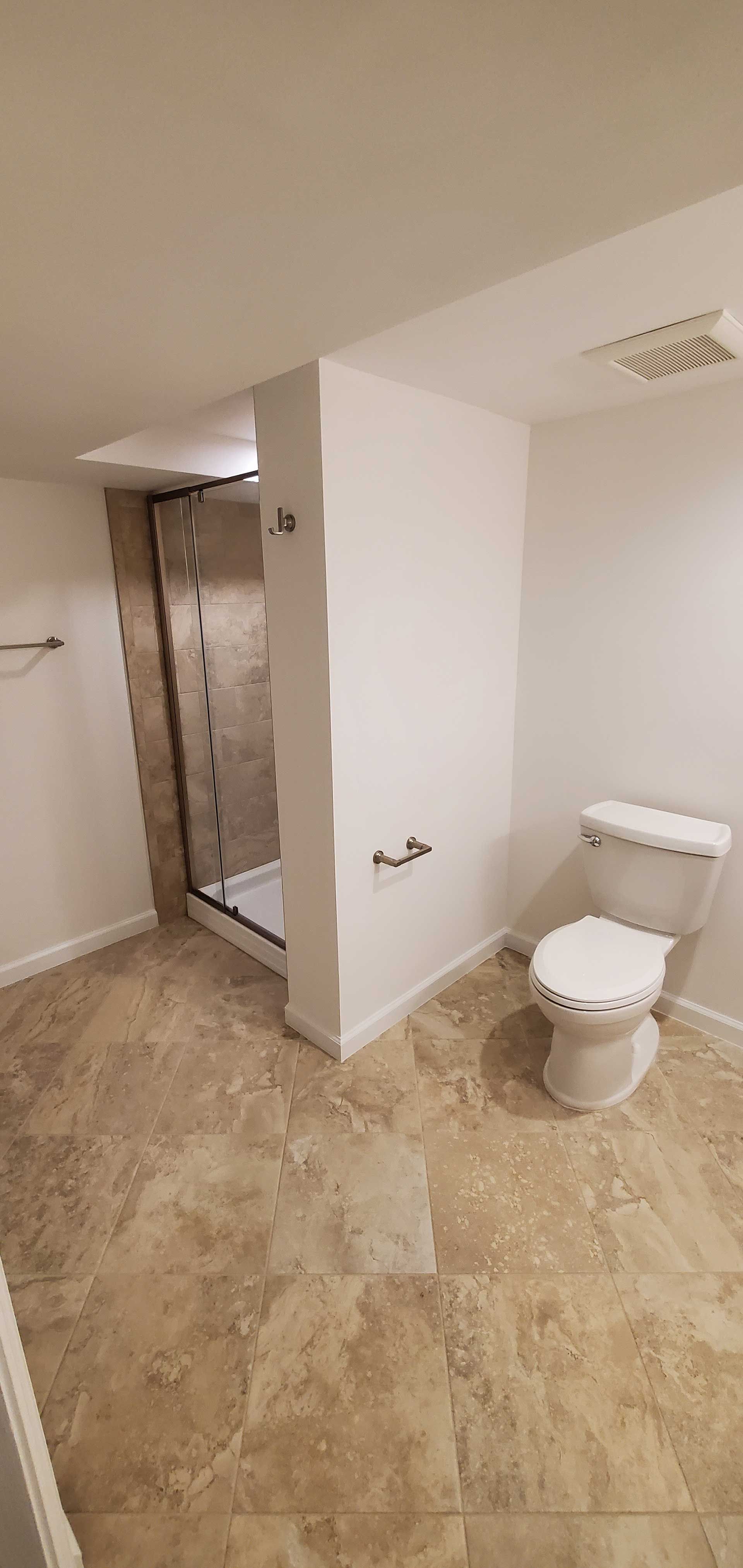 A bathroom with a toilet and a shower