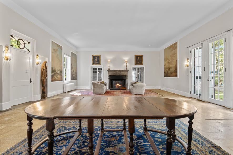 A large living room with a wooden table and a fireplace.
