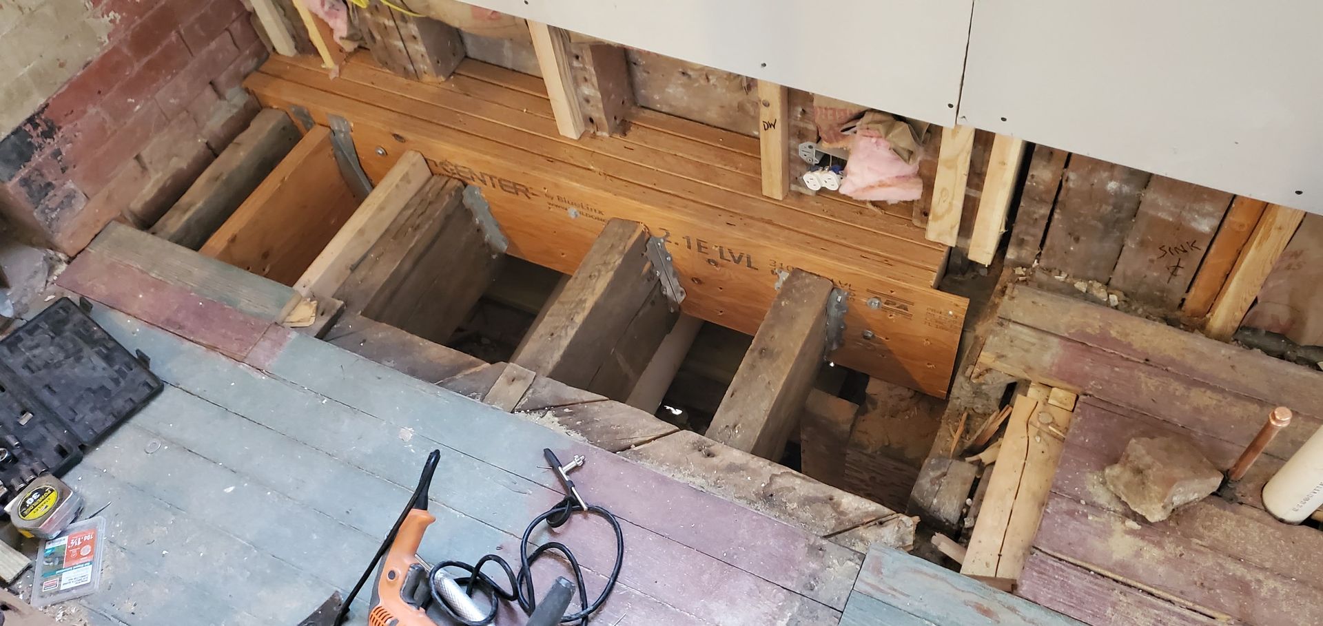 A person is working on a wooden floor in a room.