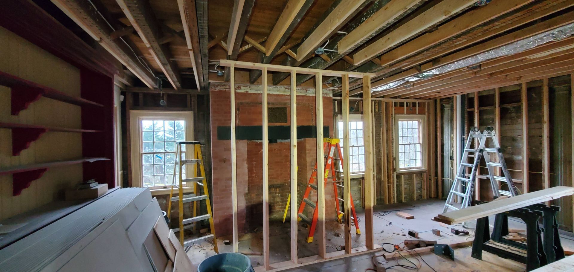 A room under construction with a ladder in the middle of it.