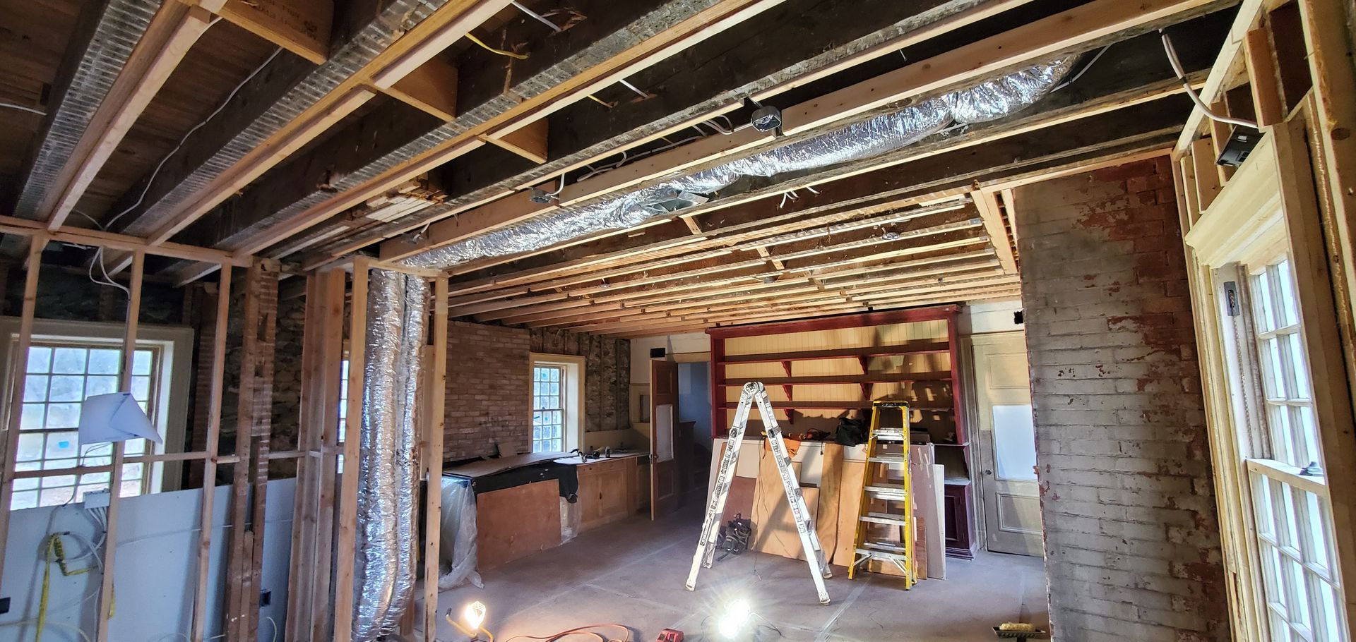 A ladder is sitting in the middle of a room under construction.