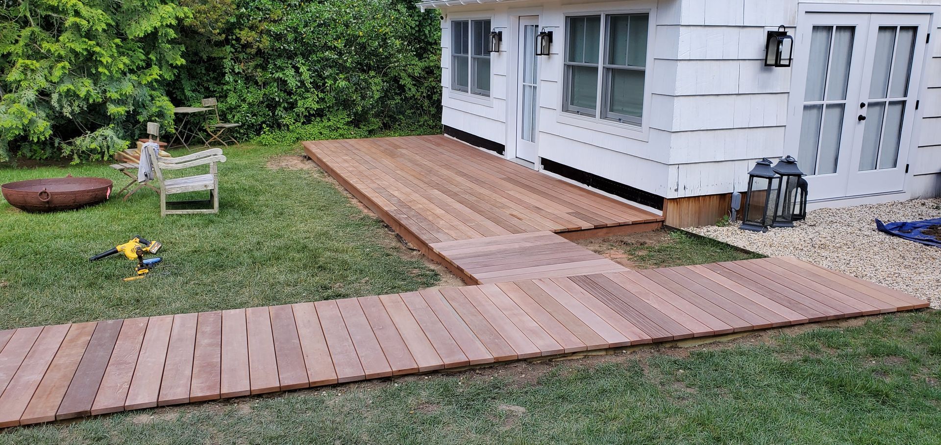 A wooden walkway is being built in front of a white house
