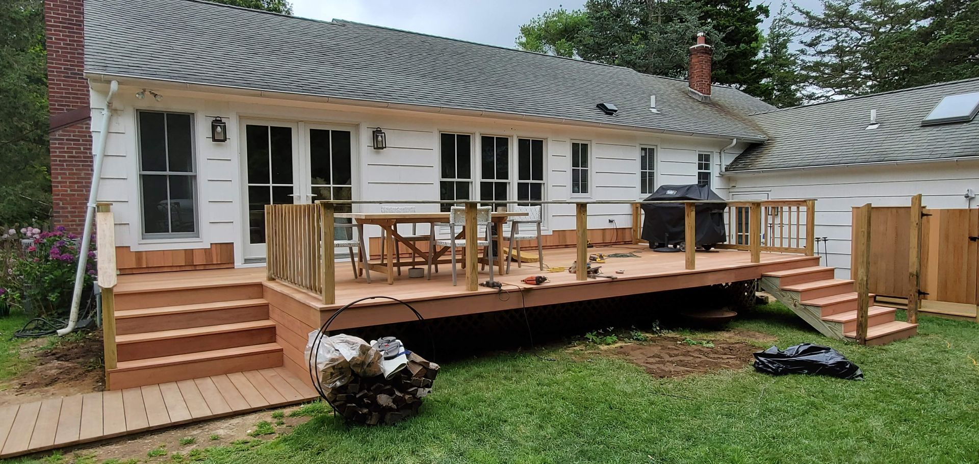 A large white house with a large wooden deck in front of it