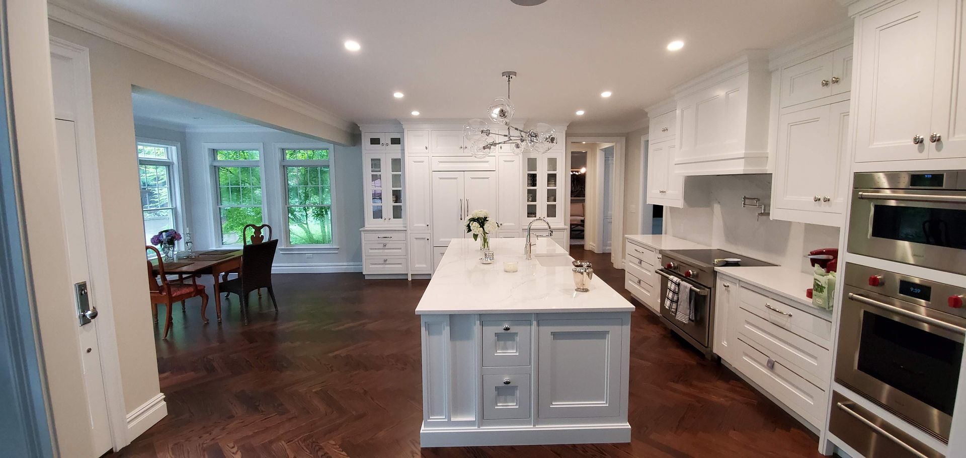 Large kitchen with white cabinets and stainless steel appliances