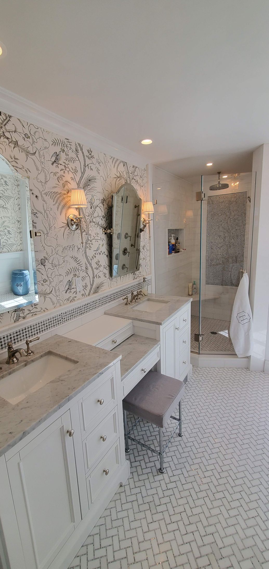 A bathroom with two sinks, a mirror, and a bench