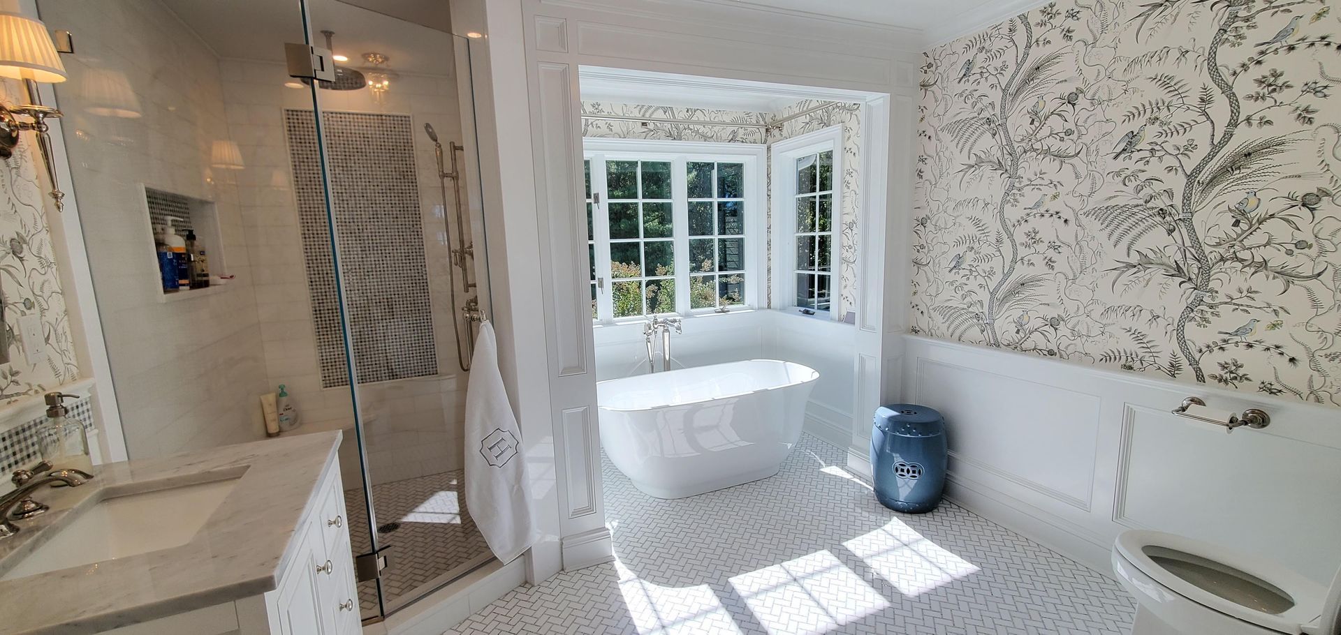 A bathroom with a tub, toilet, shower, and window