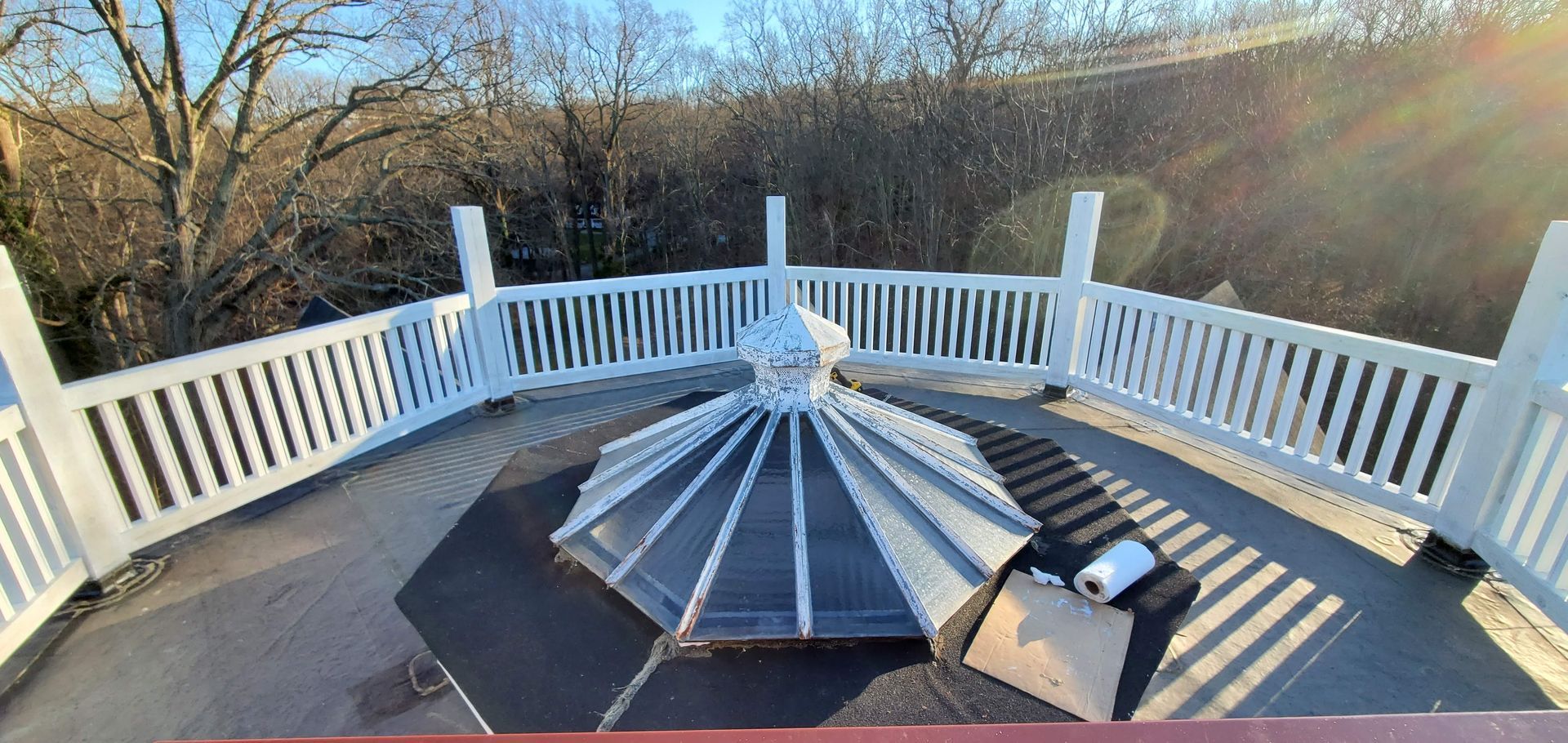 A white gazebo with a black umbrella on top of it