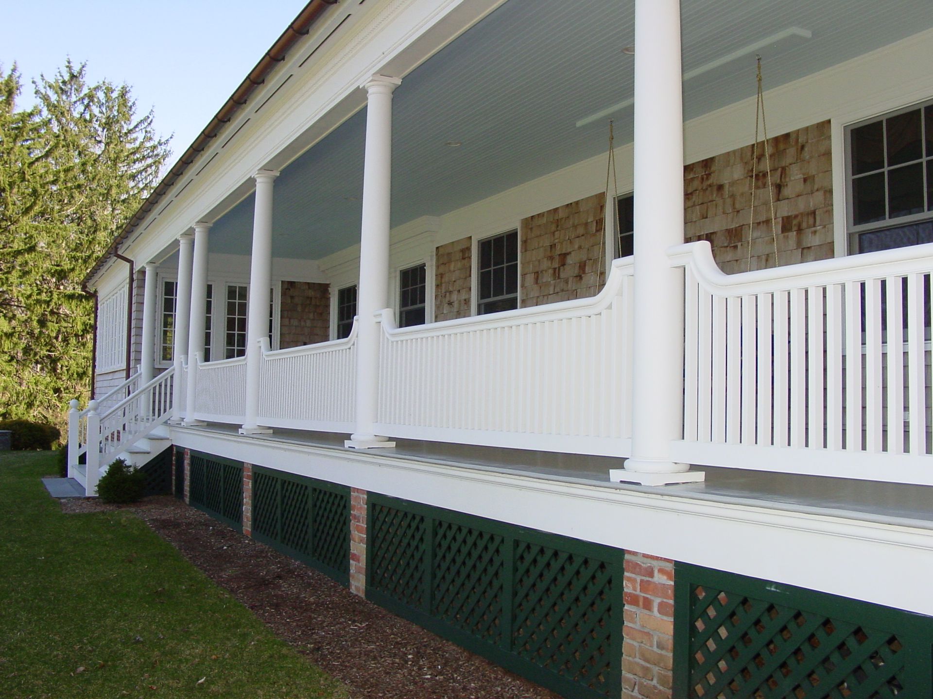 A white house with a large porch and stairs