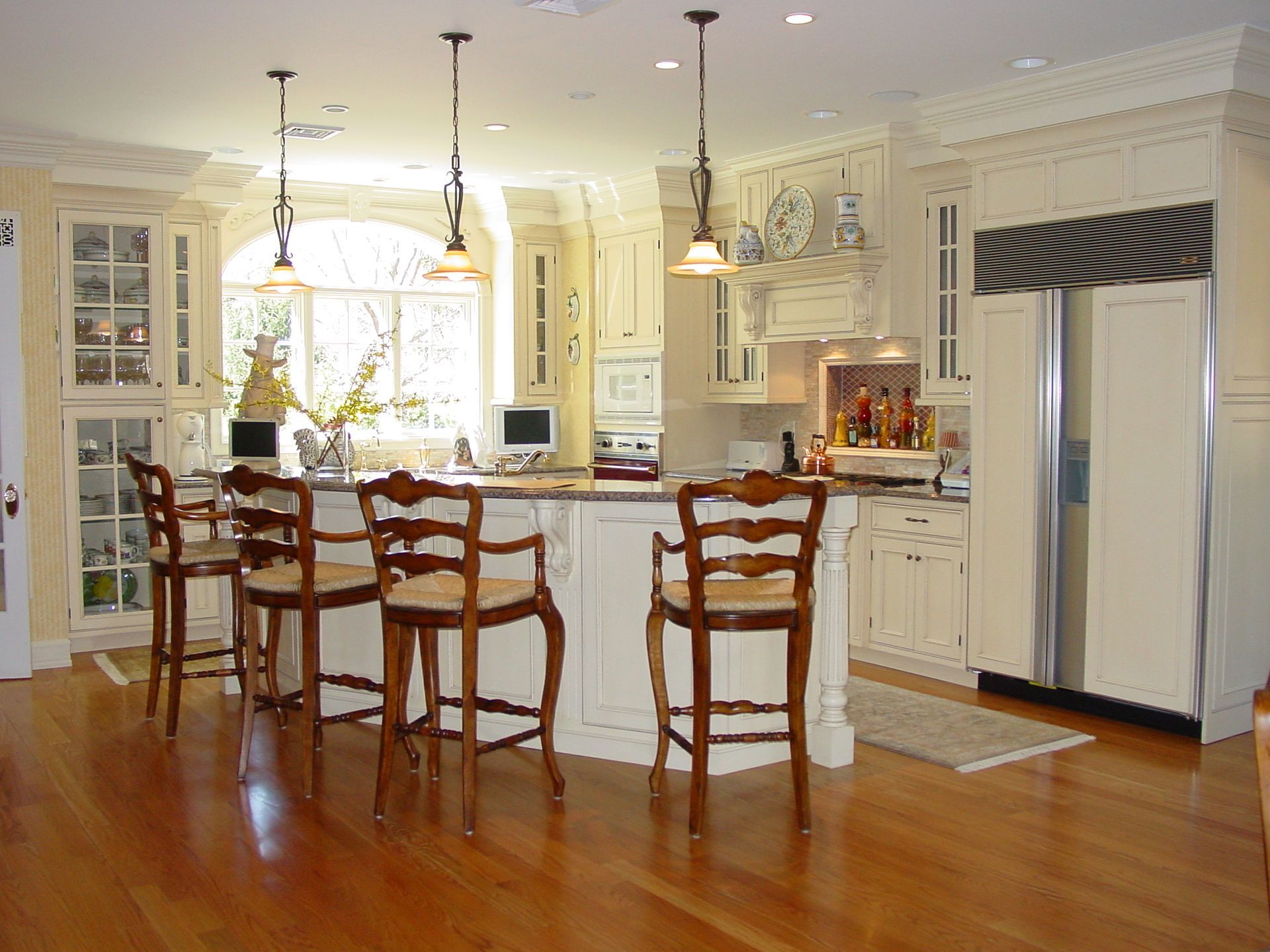 A kitchen with white cabinets and wooden stools