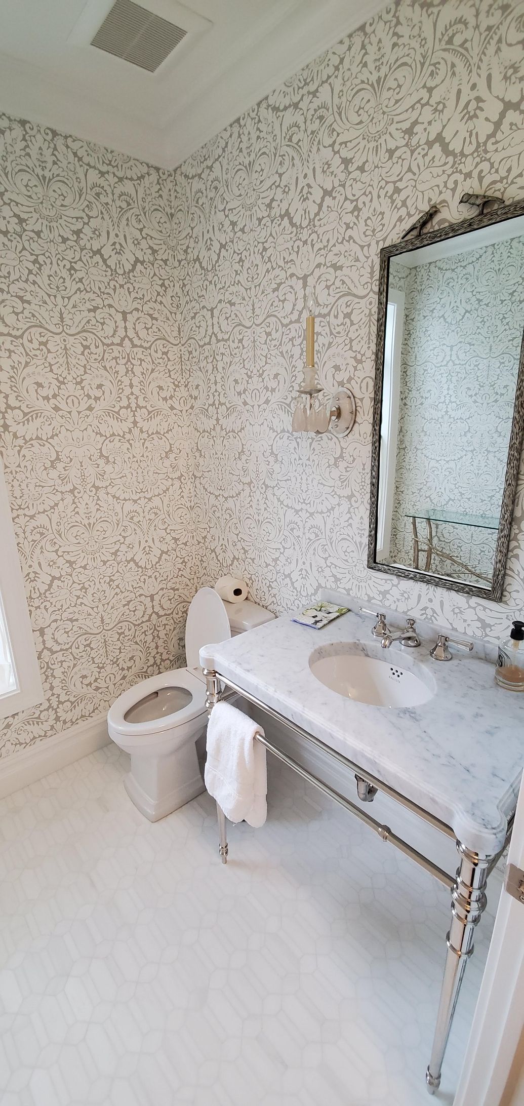 A bathroom with a sink, a toilet, and a mirror